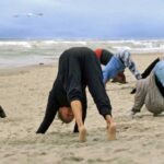 Grupa osób uprawiających jogę nad morzem, województwo Zachodniopomorskie, Mrzeżyno